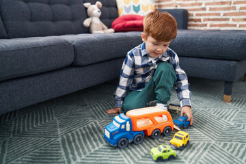 Adorable toddler playing with car toy sitting on floor at home