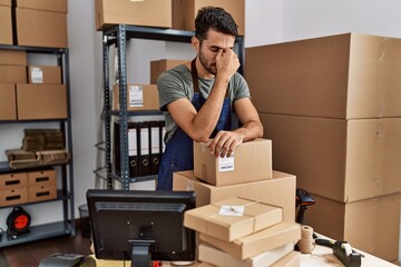 Young hispanic man business worker stressed working at storehouse