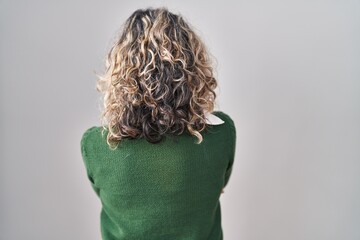 Middle age woman standing over white background standing backwards looking away with crossed arms