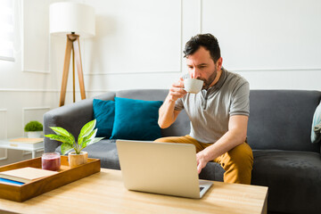 Attractive man working from home using the laptop