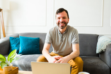 Cheerful man working on his laptop from home