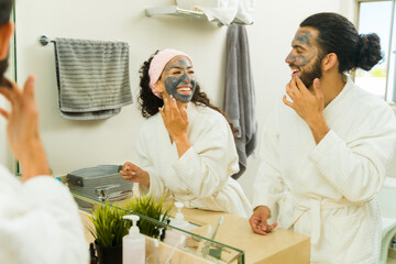 Young fresh couple using an activated charcoal mask