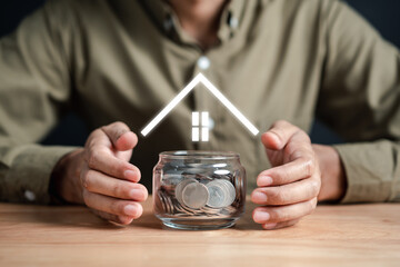 Businessman holding a money jar with a house inside to make a profit on interest real estate...