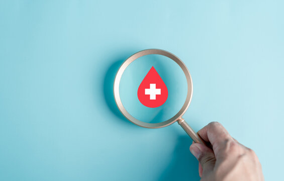 Magnifier focus to Blood drop icon, blood transfusion, world blood donor day, red cross to give blood.world hemophilia day concept