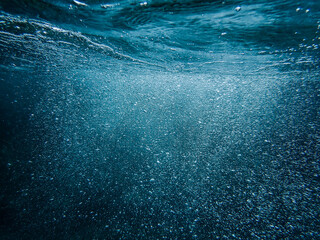 Bubbles underwater blue ocean wide background with sandy sea bottom, Real natural underwater view...