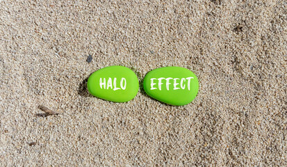 Halo effect and psychological symbol. Concept words Halo effect on beautiful green stone. Beautiful sand sea beach background. Business psychological and Halo effect concept. Copy space.