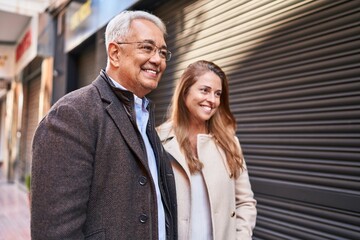 Middle age man and woman couple smiling confident standing together at street