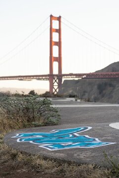 Vertical shot of a graffiti in the foreground of Golden Gate Bridge in the USA