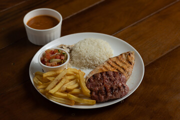 Prato de frango ou porco com linguiça e guarnições