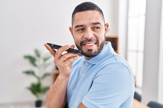 Young latin man business worker smiling confident talking on smartphone at office