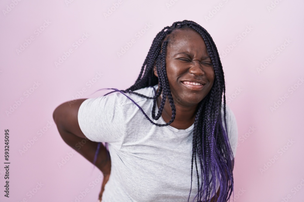 Poster Young african woman standing over pink background suffering of backache, touching back with hand, muscular pain