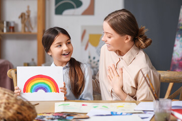 Fototapeta premium Little girl with painting and her drawing teacher in workshop