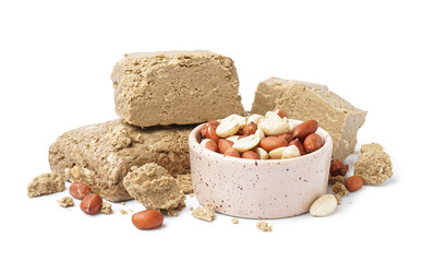 Bowl of peanuts and sweet halva on white background