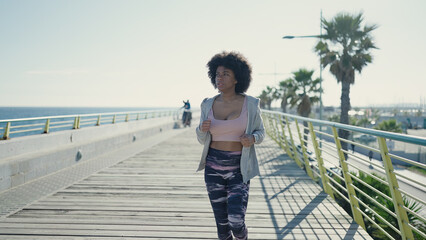 African american woman running at seaside