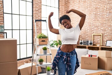 African american woman smiling confident stretching arms at new home