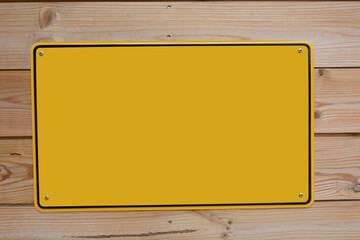 A yellow colored sign fixed on a wooden background, empty space, isolated. Mock up, template for...