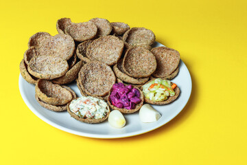 Rye bread toasts on a plate on a yellow background