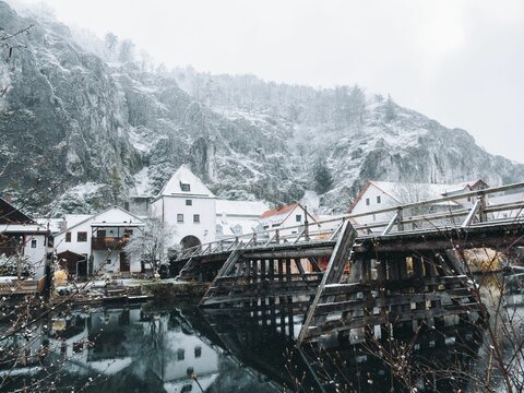 River reflecting the houses and the snow-covered mountains in the background, Kelheim, Germany