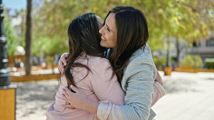 Two women hugging each other at park