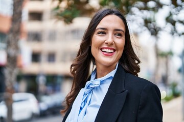 Young hispanic woman smiling confident standing at street