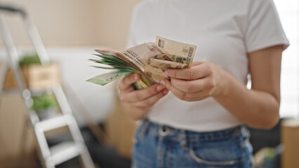 Young blonde woman counting russia rubles banknotes at new home