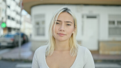Fototapeta premium Young beautiful hispanic woman standing with serious expression at street