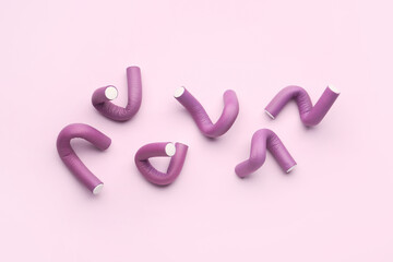 Hair curlers on pink background