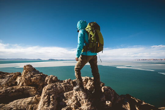 Woman hiker enjoy the ivew on mountain top cliff ege at lakeside