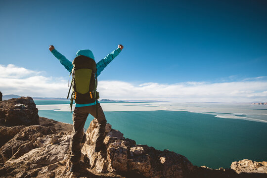 Woman hiker enjoy the ivew on mountain top cliff ege at lakeside