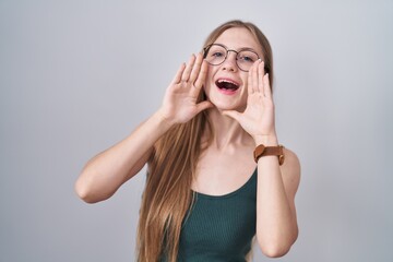Young caucasian woman standing over white background smiling cheerful playing peek a boo with hands...