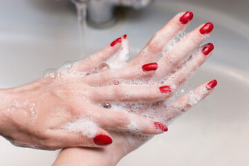 Fototapeta premium Washing hands with red nails