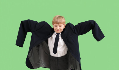 Funny little businessman in big jacket on green background
