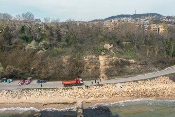 Landslides and rockfalls on the road in the forest. Aerial view: mud and rocks blocking the road...