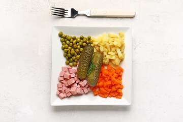 Plate with ingredients for Olivier salad on light background