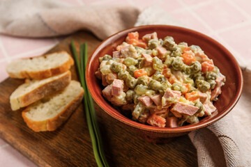 Bowl of tasty Olivier salad on table