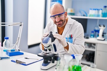 Young man scientist using microscope at laboratory