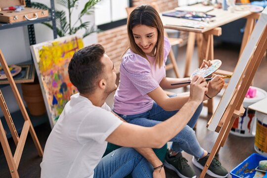 Man and woman artists couple smiling confident drawing at art studio