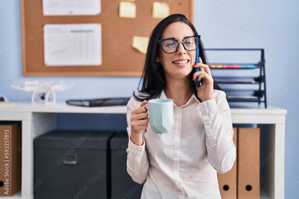 Sticker Young caucasian woman business worker talking on smartphone drinking coffee at office