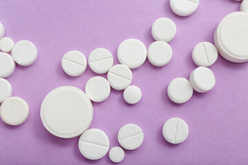 White pills on lilac background