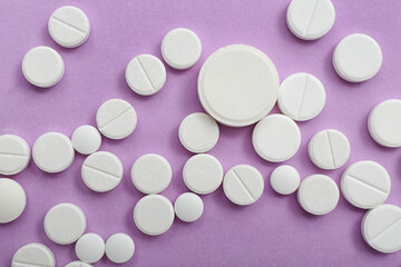 White pills on lilac background