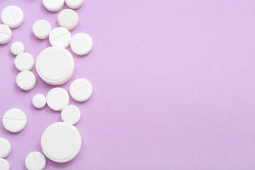 Obraz na płótnie Canvas White pills on lilac background