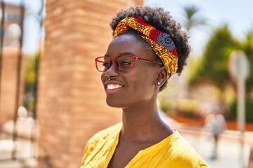 Young african american woman smiling confident wearing glasses at street