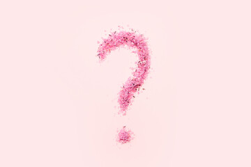 Question mark made of sea salt on pink background
