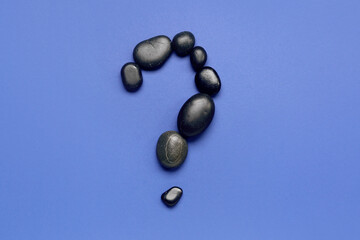 Question mark made of spa stones on blue background