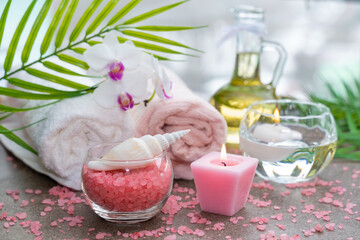 Starfish, seashells, terry towel, candle and plant on the sand. Spa and wellness concept