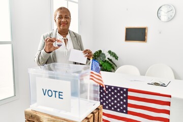 Senior african american woman holding i voted badge voting at electoral college