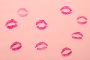 Lipstick kiss marks on pink background