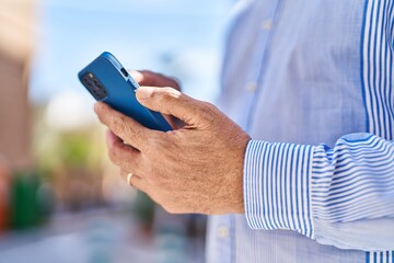 Senior man using smartphone at street