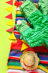 Fototapeta na wymiar Mexican pinata with sombrero hat, flags and serape on green background