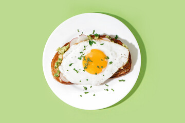 Delicious sandwich with fried egg on green background